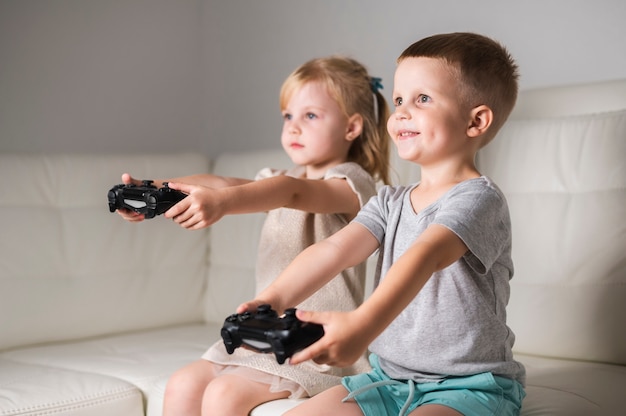 Broers en zussen thuis spelen met joystick games
