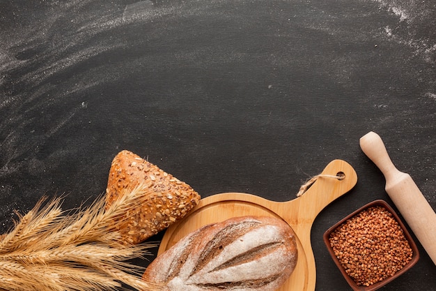 Brood op een houten bord en deegrol met tarwe