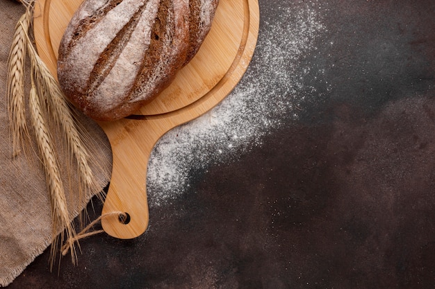 Brood op een houten bord met tarwegras en bloem