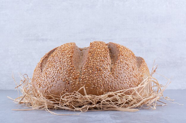 Brood zittend op een stapel stro op marmeren oppervlak