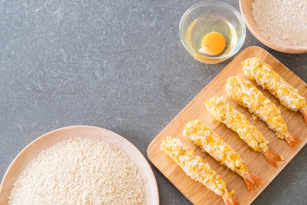 Gratis foto broodgebakken garnalen op houten bord