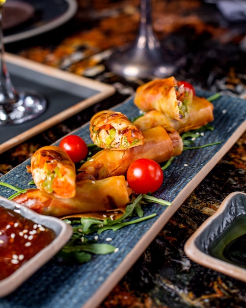 Gratis foto broodjes geserveerd met tomaten, rucola en saus 1