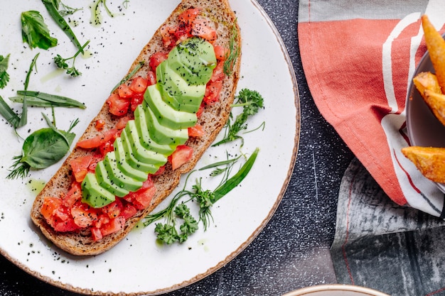 Broodsandwich met cjopped tomaten, komkommers en kruiden.