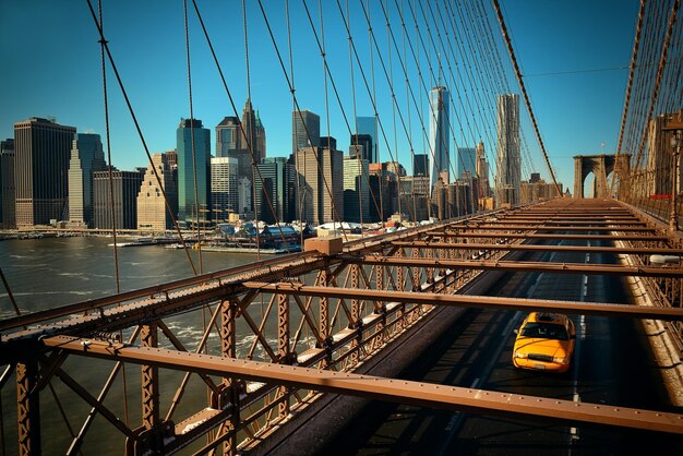 Brooklyn Bridge uitzicht op Manhattan met gele cabine en wolkenkrabbers.