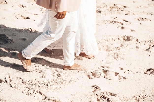 Bruid en bruidegom die samen langs het strand lopen. Romantisch bruidspaar