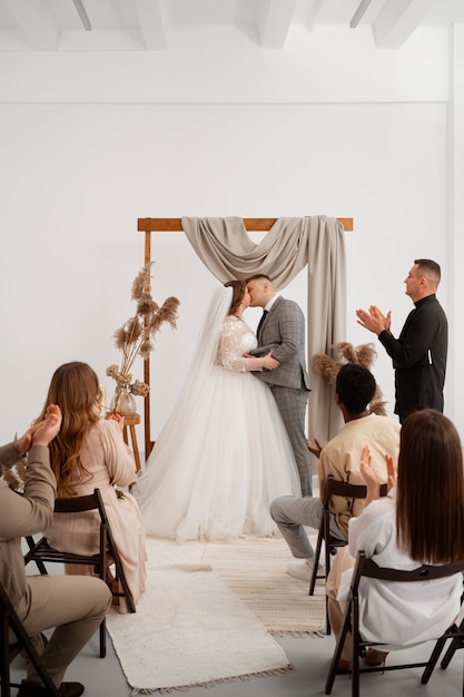 Gratis foto bruid en bruidegom kussen tijdens huwelijksceremonie