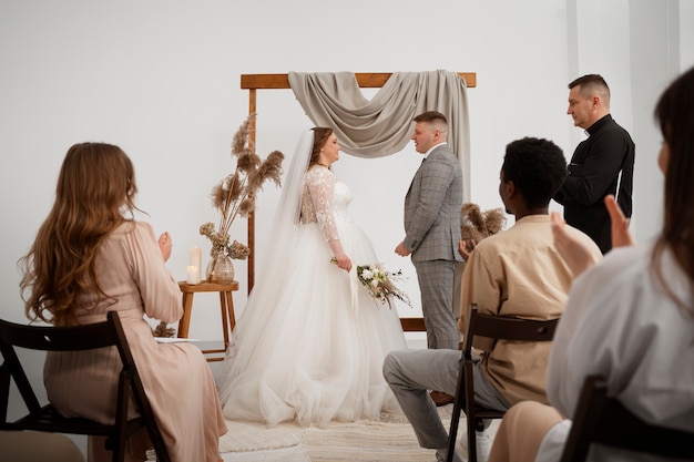 Gratis foto bruid en bruidegom wisselen geloften uit tijdens de huwelijksceremonie