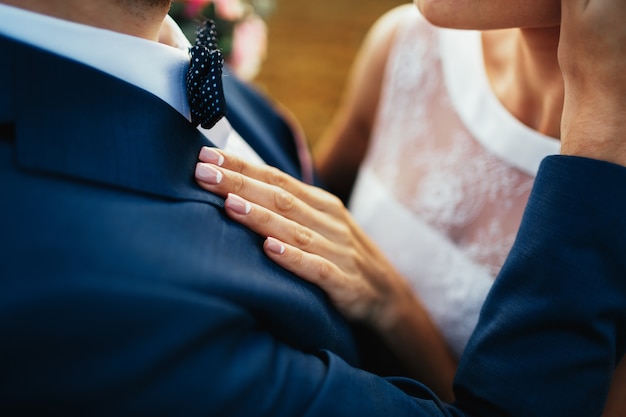 Gratis foto bruid houdt haar hand op de borst van de bruidegom