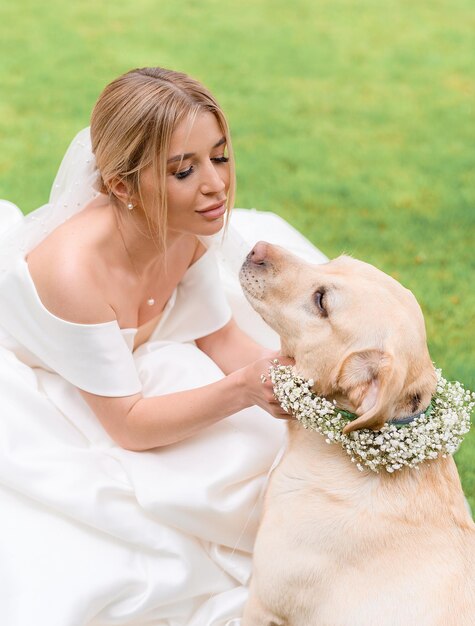 Bruid in jurk die plezier heeft terwijl ze buiten naar de hond kijkt