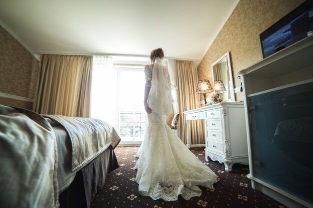Bruid met kleding in een kamer