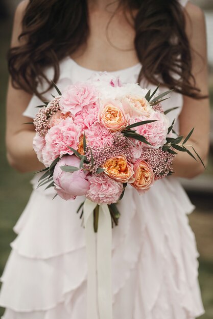Bruid met luxe boeket roze rozen en pioenen