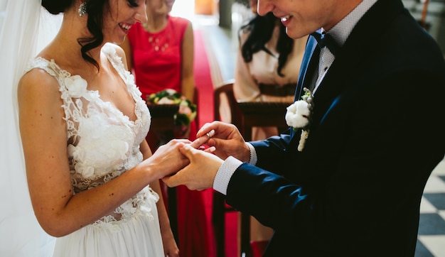 Bruidegom die de ring op de vinger van de bruid