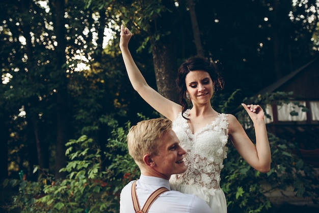 Bruidegom houdt zijn bruid ergens in de natuur in zijn armen