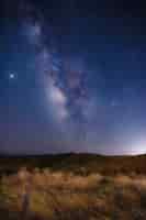 Gratis foto bruin grasveld onder blauwe hemel tijdens nacht
