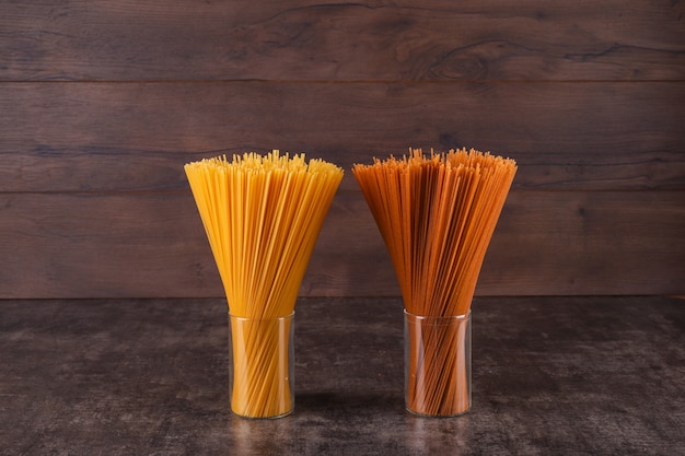 bruine en gele spaghetti in glazen op houten oppervlak