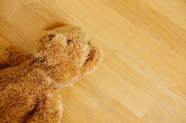 Gratis foto bruine schattige teddybeer op de houten vloer