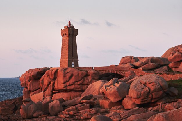 Bruine vuurtoren op rotsklip dichtbij waterlichaam