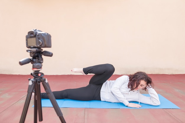 Gratis foto brunette blogger die yogaroutine opneemt