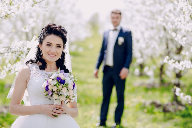 Brunette bruid in het veld met onscherpe achtergrond boyfriend