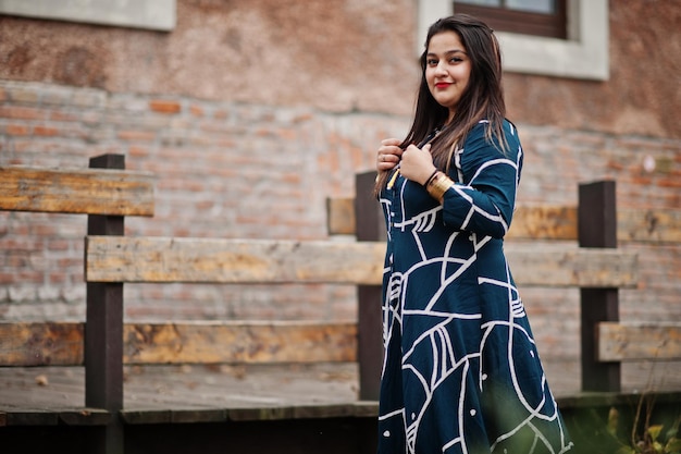 Brunette indiase vrouw in lange modieuze jurk poseerde buiten