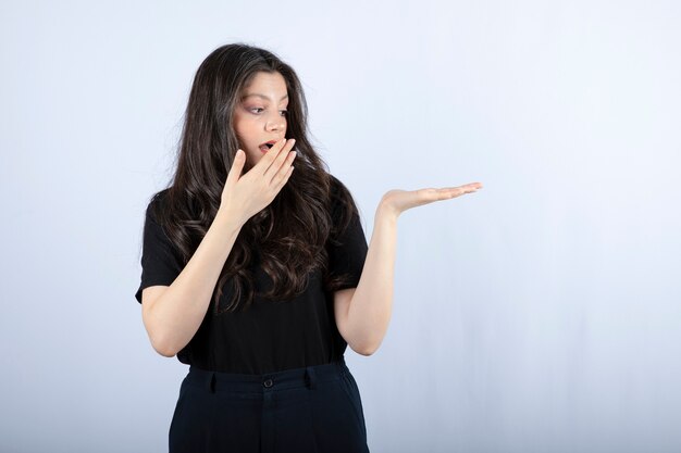 brunette meisje in zwarte top iets op haar hand te kijken.