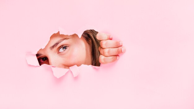 Brunette meisje poseren door een papier-gat