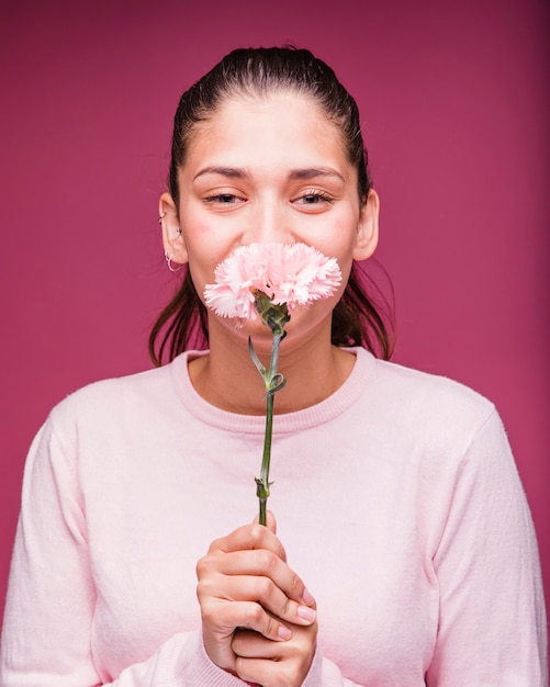 Gratis foto brunette meisje poseren met anjer