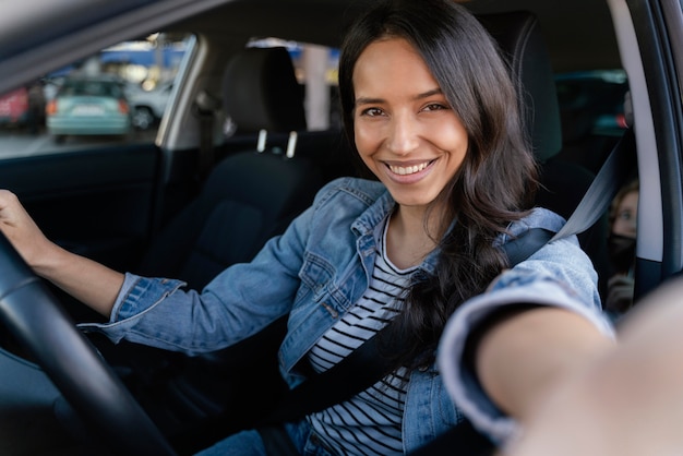 Brunette vrouw die een selfie in haar auto