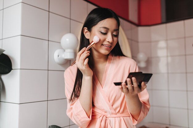 Brunette vrouw doet haar ochtendroutine in de badkamer