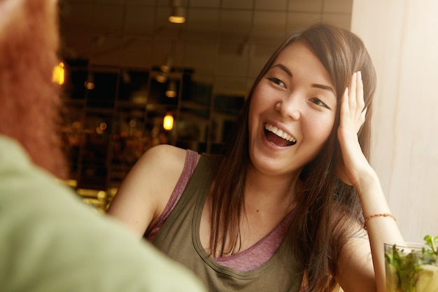 Brunette vrouw en gember man zitten in café