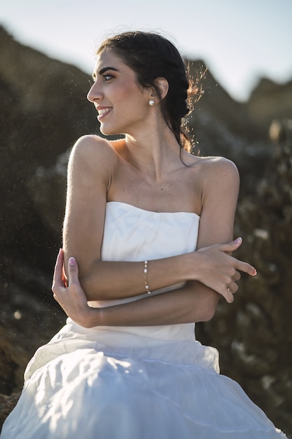 brunette vrouw in een witte jurk met een oprechte glimlach