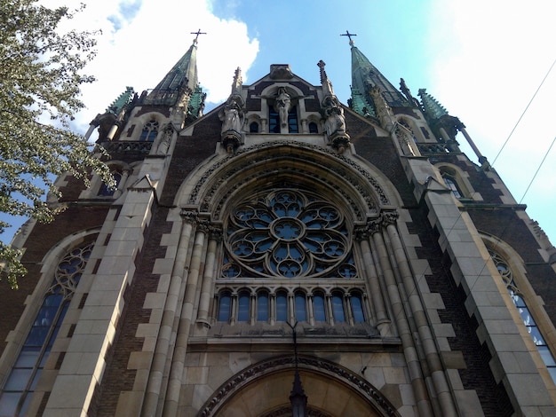 Buiten lage hoek die van een mooie kathedraal met wolken in blauwe hemel is ontsproten