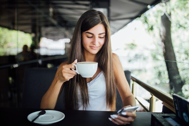 Buiten mode portret van mooi jong meisje alleen thee, koffie drinken