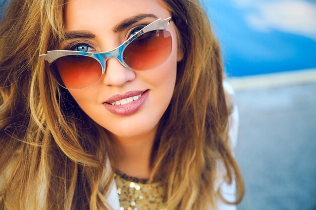 Buiten mode portret van mooie vrouw met perfecte huid, alleen dromen en kijken op de vloer. en geniet van haar gedachten, heb natuurlijke make-up, poseren in de zeehaven.