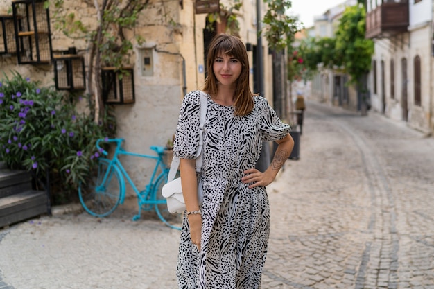 Buiten zomer portret van mooie vrouw wolking in oude Europese stad.