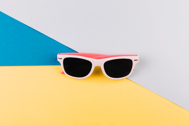 Buitensporige zonnebril op kleurrijke achtergrond