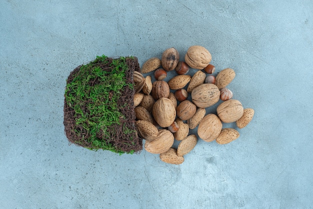 Bundel van noten die uit een mooie kom op marmer gieten.