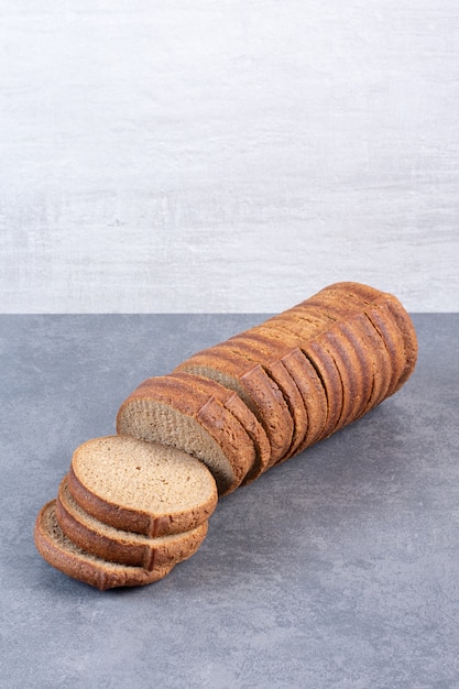 Bundel van zwarte sneetjes brood op marmer.