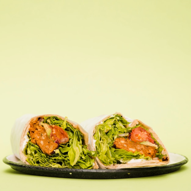 Gratis foto burrito wraps op plaat over mintgroene achtergrond