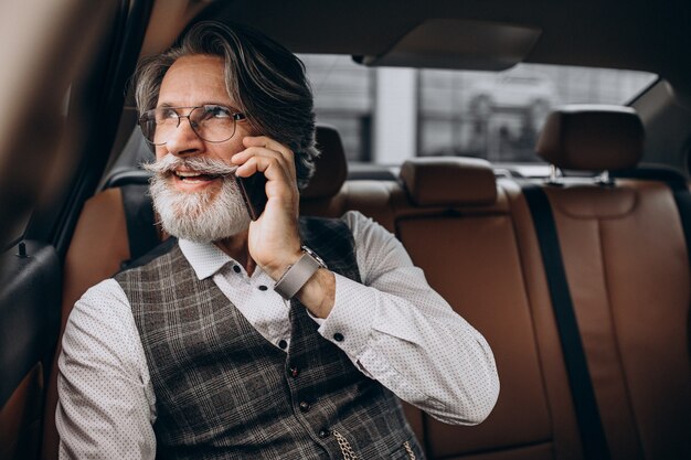 Business man zit in zijn auto aan de achterkant zitten