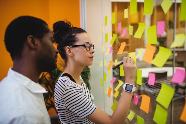 Business managers schrijven op sticky notes