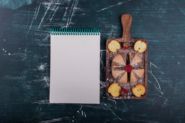 Cacao en vanille koekjes op een houten bord met een notebook opzij