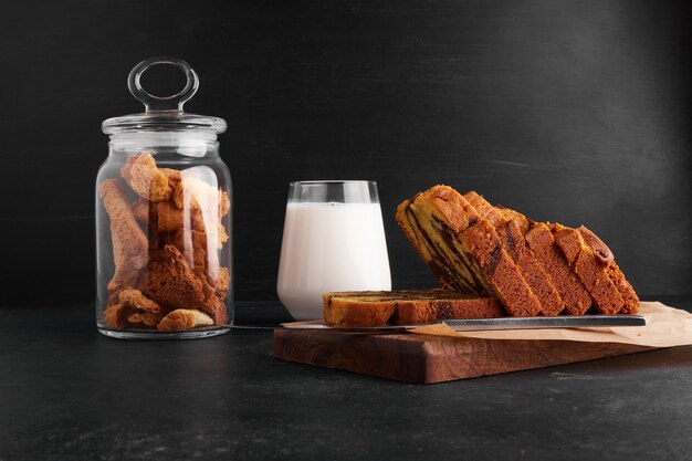 Cacaopastei plakjes op een houten bord met een glas melk en droge vruchten.