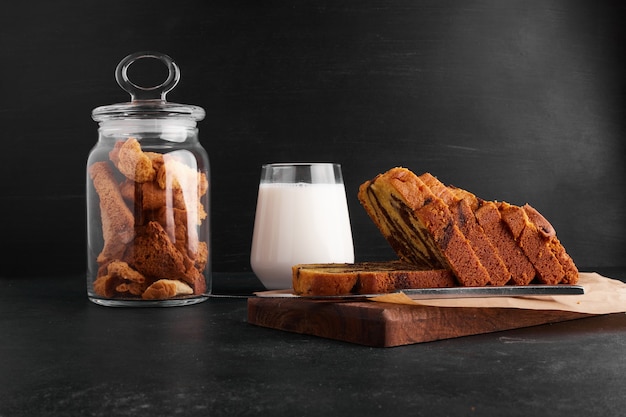 Cacaopastei plakjes op een houten bord met een glas melk en droge vruchten.