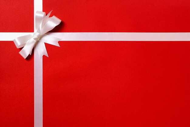 Cadeaupapier witte strik rood papier achtergrond