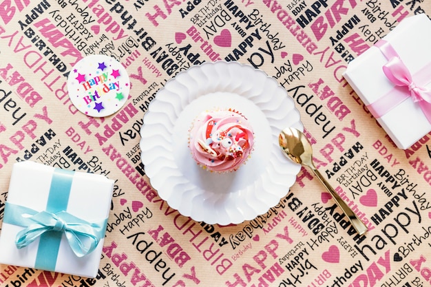 Gratis foto cadeaus en cupcake op inpakpapier