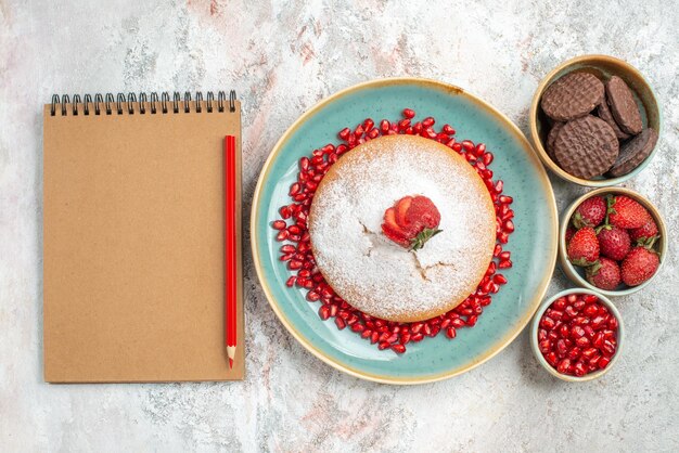 cake cookies cake met aardbeien naast het potlood notitieboekje