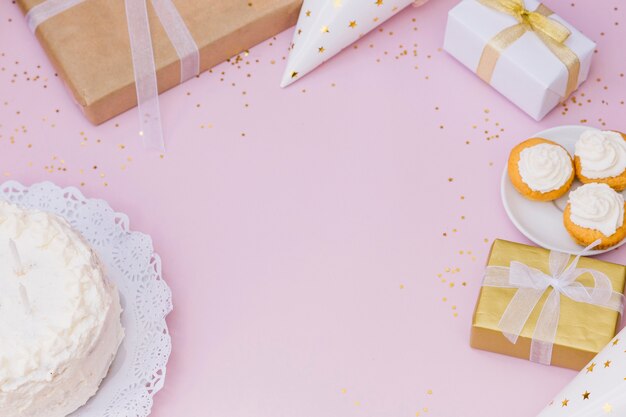 Cake; geschenkdoos; presenteert; geschenkdoos en confetti op roze achtergrond