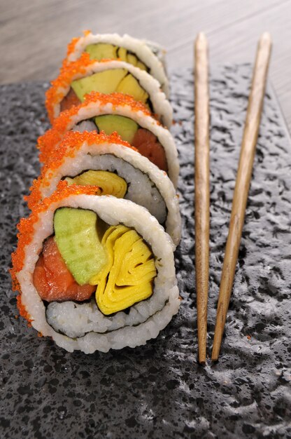Gratis foto california roll sushi met kaviaar en eetstokjes