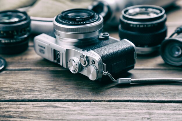 Camera, lens, verrekijker, canvas schoenen, sportfles op de retro houten tafel